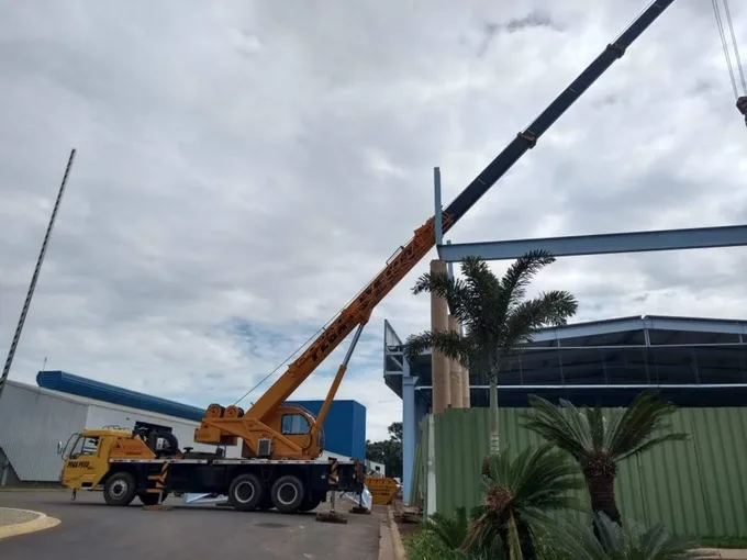 Guindaste Pega Peso montando viga de estrutura metálica em galpão industrial em Piracicaba